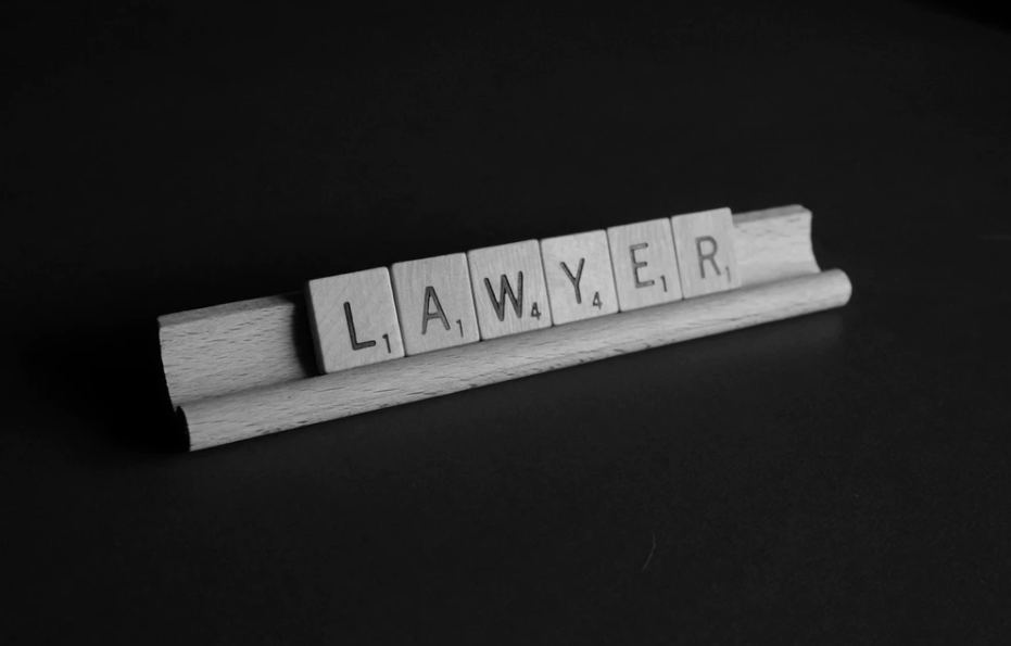 Na biurku stoi drewniany napis prawnik po angielsku