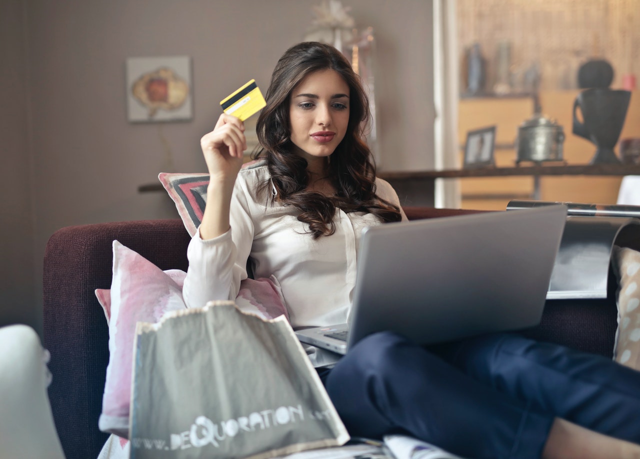 Kobieta z laptopem robi zakupy przez internet